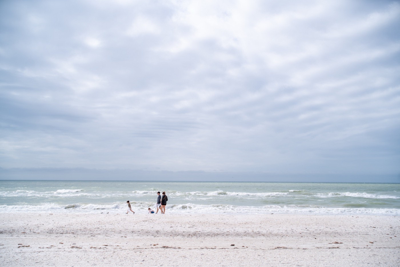 Family walking together along the waves on a Gulf beach